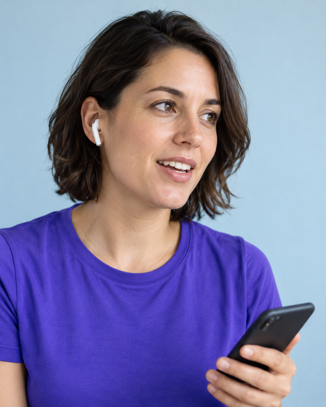 A creator coach listening through an earbud in a bright studio